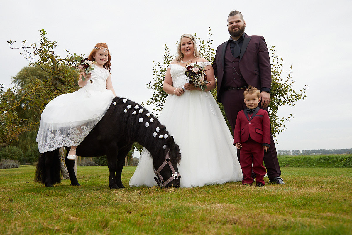 huwelijksfoto met bruidkinderen en de pony van Gerda